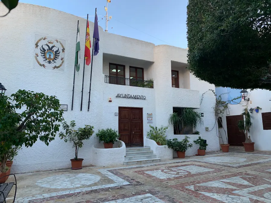 Fachada del Ayuntamiento de Mojácar en verano, rodeado de vegetación y arquitectura típica andaluza, uno de los lugares más emblemáticos del pueblo